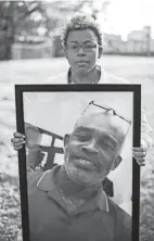  ?? ADAM CAIRNS/COLUMBUS DISPATCH ?? Jada Mcdaniel holds a portrait of her brother, Michael Mcdaniel, who died Feb. 6, 2021, after a violent clash with guards at the Correction­al Reception Center.