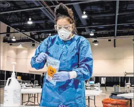  ?? Elizabeth Brumley Las Vegas Review-journal ?? UMC respirator­y therapist Diana Vega seals a COVID-19 test in a biohazard bag at a COVID-19 testing site inside Cashman Center Exhibit Hall A on Aug. 3.