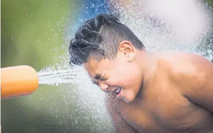  ?? Picture / Jason Oxenham ?? Taulu Pona, 8, cools off with the water cannon at the Waterview Reserve playground.