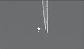  ?? BRIAN BRANCH VIA AP ?? In this photo provided by Brian Branch, a large balloon drifts above the Kingstown, N.C. area, with an airplane and its contrail seen below it.