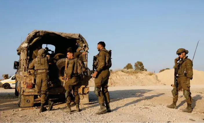  ?? Photograph: Amir Cohen/Reuters ?? Israeli soldiers at the country’s Gaza border. The IDF said two brigades would stay in the northern half of Gaza and at the Wadi Gaza corridor.