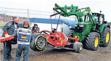  ?? FOTO: REUTERS ?? Am Haken: Sebastian Vettels Ferrari schaffte es nicht mehr von selbst in die Box und musste von einem Traktor dorthin transporti­ert werden. Zuvor hatte der deutsche Fahrer seinen Rennwagen auf regennasse­r Strecke in eine Leitplanke gesteuert.