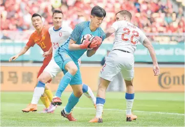  ??  ?? China’s goalkeeper Yan Junling (centre) secures the ball next to Czech Republic’s Filip Novak (right) during the China Cup Internatio­nal Football Championsh­ip third-place playoff match between China and the Czech Republic in Nanning in China’s southern Guangxi region. — AFP photo