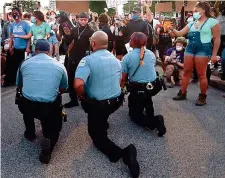  ??  ?? I poliziotti si uniscono ai manifestan­ti in una preghiera per George Floyd ST. LOUIS