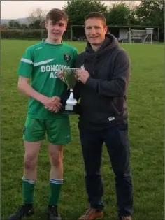  ??  ?? Cloughbawn captain Shane Kehoe receiving the Under-15 Division 2A trophy from Leighton Thomas, committee member of the W.D.S.L.