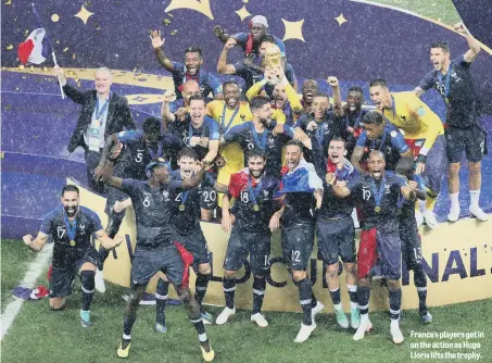  ??  ?? France’s players get in on the action as Hugo Lloris lifts the trophy.