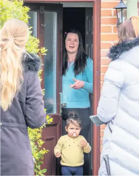  ?? Dominic Lipinski/Press Associatio­n ?? > Volunteers talk to residents yesterday as they distribute test packs during door-to-door coronaviru­s testing in Woking, Surrey, part of a quest to find cases of the South Africa coronaviru­s variant in a bid to stop the spread of the more infectious strain