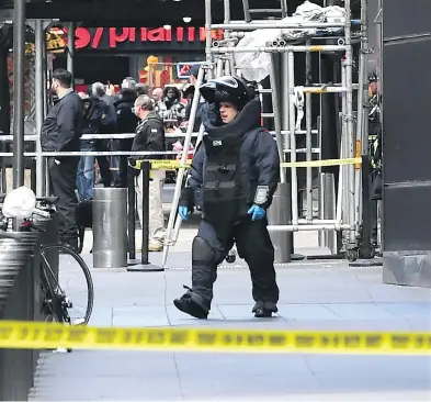  ?? TIMOTHY A. CLARY / AFP / GETTY IMAGES ?? A bomb squad unit exits the New York building where a suspected explosive device was delivered to CNN.