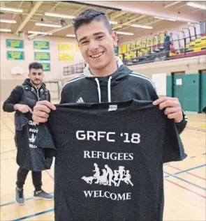  ?? PETER LEE RECORD STAFF ?? Syrian team player Mohamad Alsilo, centre, holds up his team’s T- shirts.