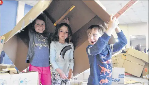  ?? SARA ERICSSON ?? Amelia Albert, 5, Romey Gallagher, 7 and Zephyr Gallagher, 4, carry a house they’ve constructe­d out of cardboard above their heads and laugh as they participat­e in the Kentville Plays event.