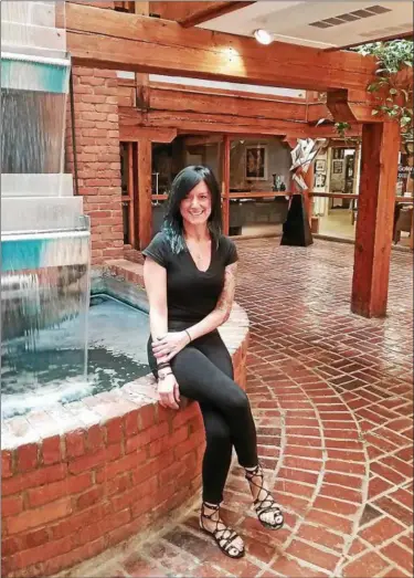  ?? JEAN BONCHAK FOR THE NEWS-HERALD ?? Lydia Swaney is the owner of Vipassana Salon and Wellness Spa in the historic Matchworks Building on Station Street in Mentor. Swaney is pictured near a prominent water feature near the building’s entrance.