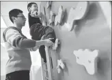  ?? FANG DONGXU / FOR CHINA DAILY ?? He Guangmin, a special education teacher, instructs a boy in rock climbing in Nanjing, Jiangsu province.