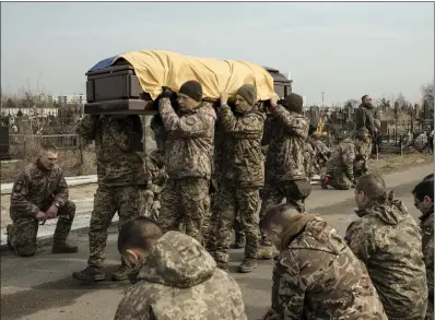  ?? EMILE DUCKE — THE NEW YORK TIMES ?? Ukrainian soldiers carry the coffin of Ihor Dyukarev, 24, a fellow soldier who was killed while fighting in the Luhansk region, at the cemetery in Bucha, Ukraine, on Saturday one year and a day after Russia launched its full-scale invasion.