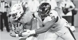 ?? LYNNE SLADKY/ASSOCIATED PRESS ?? Defensive tackle Carl Davis, tackling Dolphins running back Buddy Howell in a preseason game in August, spent his first three seasons in the NFL with the Ravens.