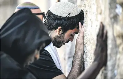  ?? PHOTO: RONALDO SCHEMIDT/AFP ?? People pray at the Western Wall, the holiest site where Jews are allowed to worship, in the old city of Jerusalem yesterday.
nd