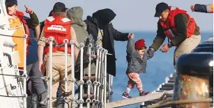  ?? (Murad Sezer/Reuters) ?? MIGRANTS DISEMBARK from a Turkish Coast Guard vessel after a failed attempt at crossing to the Greek island of Lesbos, in the Turkish coastal town of Dikili.