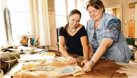  ?? Fotos: Silvio Wyszengrad ?? Die langjährig­en Mitarbeite­rinnen Heidi Münch (links) und Brigitte Schoof lassen sich in der Werkstatt der Gerberei Aigner bei der Arbeit an einer Lederhose über die Schulter schauen.