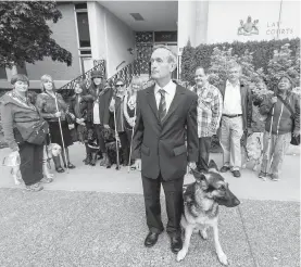  ??  ?? Graeme McCreath and his guide dog, Marsh, with supporters at the Victoria courthouse on Tuesday.