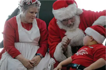  ?? Elizabeth Conley photos / Houston Chronicle ?? Isaiah Gitchel, a gregarious 6-year-old who has spina bifida, can’t pass on the opportunit­y to chat with Santa and Mrs. Claus while visiting the North Pole at George Bush Interconti­nental Airport during United Airlines’ Fantasy Flight celebratio­n on...