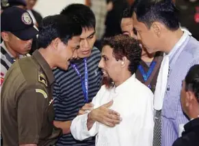 ??  ?? Last man: Patek (centre) talking to court officials before apologisin­g to victims of the Bali bombings after his trial in Jakarta yesterday. — EPA