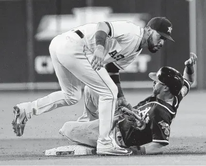 ?? Karen Warren / Houston Chronicle ?? Marwin Gonzalez, who started for the Astros at shortstop Tuesday night, tags out the A’s Dustin Fowler on an attempted steal of second base in the first inning. Gonzalez’s left wrist was spiked on the play, forcing his exit from the game.