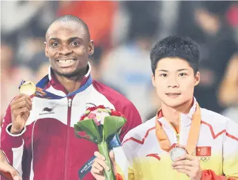  ??  ?? Qatar’s gold medalist Femi Ogunode (le ) and China’s silver medalist Su Bingtian stand during the 100m victory ceremony at the 2014 Asian Games in Incheon, South Korea.