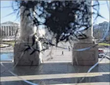  ?? Brendan Smialowski / Getty Images ?? The Supreme Court is seen through a broken window on Thursday, a day after a pro-trump mob broke into the U.S. Capitol in Washington.