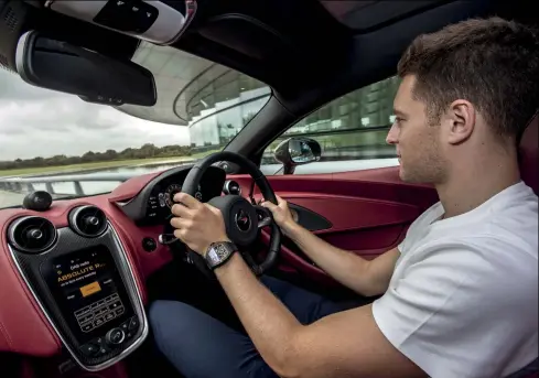 ??  ?? Getting to grips with the controls in the luxurious leather interior of Mclaren’s latest high-performanc­e sportscar