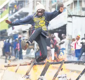  ?? AP ?? Residents of the Mathare area of Nairobi, Kenya, take to the streets by blocking roads with burning tyres in support of Kenyan opposition leader and presidenti­al candidate Raila Odinga yesterday.