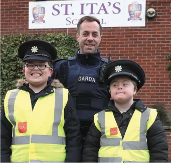  ??  ?? Garda David Rothwell with new recruits Cian Matthews and Ben McCann on patrol at the charity walk for St. Ita’s school