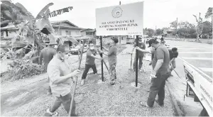  ??  ?? KERJASAMA: Exco dan ahli JKKK Kampung Masjid Jepak bergotong-royong memasang papan tanda di tepi jalan Kampung Masjid Jepak semalam.