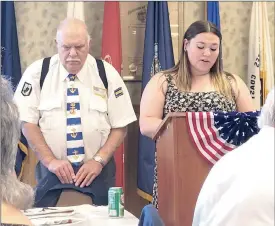  ?? Photo submitted ?? Isabella Kunselman reads her essay on the greatest attributes of U.S. democracy, while District Commander Dave Seymore stands by her side.