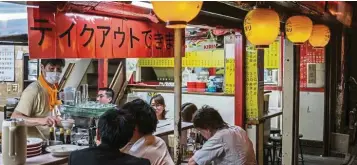  ?? — AFP ?? Business closure: People eat at a restaurant in Tokyo. Covid-19 has caused broad economic pain to Japan, with the number of furloughed workers standing at 4.23 million.