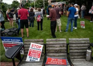  ?? AFP via Getty Images ?? Signs are seen on a bench during a rally against “critical race theory” (CRT) being taught in schools at the Loudoun County Government center in Leesburg, Virginia on June 12, 2021.