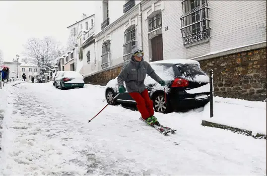  ??  ?? Seizing the opportunit­y: A man skiing on a snow covered street of Montmartre following heavy snowfall in Paris. — AFP