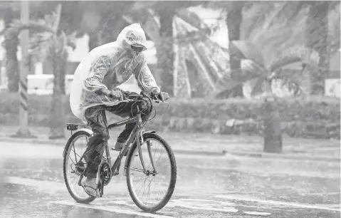  ?? RITCHIE B. TONGO, EUROPEAN PRESSPHOTO AGENCY ?? A man pushes through heavy rain as Typhoon Megi hits Taiwan on Tuesday. Megi’s heavy winds caused high waves on the coast.