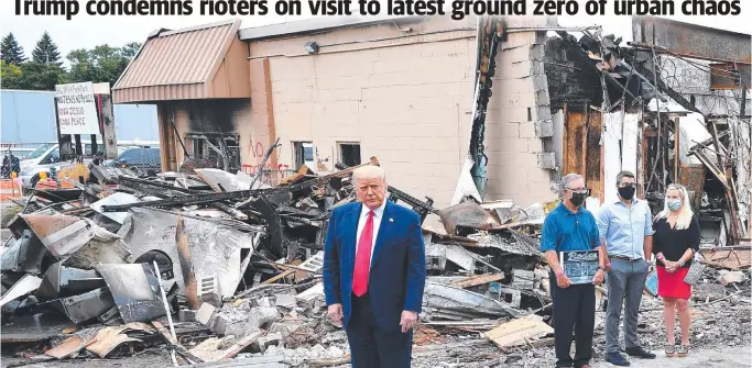  ?? Pictures: AFP ?? President Donald Trump tours an area affected by civil unrest in Kenosha, Wisconsin, on Tuesday, local time. Below left: A Black Lives Matter protester, left, brawls with a Trump supporter. Below right: National Guard troops move in.