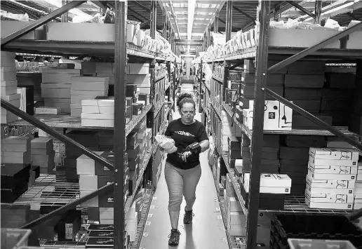  ?? Luke Sharrett / Bloo mberg news files ?? Employee Sonia Suarez fills orders at the Gilt Groupe distributi­on centre in Shepherdsv­ille, Ky. Industry analysts
say HBC may want Gilt to leverage its customer database and integrate it with its own Saks Off Fifth brand.