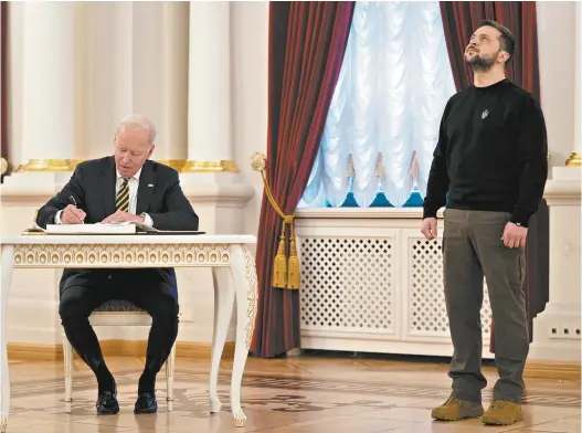  ?? Evan Vucci / AFP ?? US President Joe Biden signs the guest book during a meeting with Ukrainian President Volodymyr Zelensky in Kyiv on February 20.