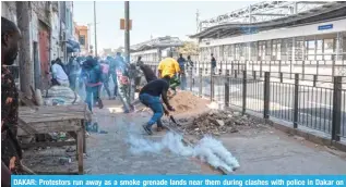  ?? — AFP ?? DAKAR: Protestors run away as a smoke grenade lands near them during clashes with police in Dakar on February 9, 2024.