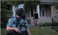  ??  ?? A police officer keeps watch during a protest in a residentia­l area in St Paul, Minnesota.