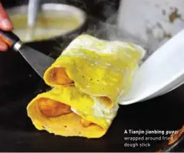  ??  ?? A Tianjin jianbing guozi wrapped around fried dough stick