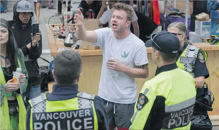  ?? PHOTOS: JASON PAYNE/PNG ?? Robert Moore, CEO of World Cannabis, talks to police during the annual Cannabis Day festivitie­s outside the Vancouver Art Gallery on Friday.