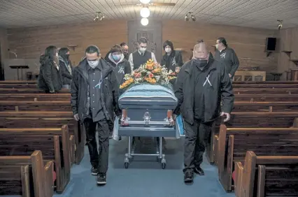  ?? Photos by Victor J. Blue, © The New York Times Co. ?? Pall bearers with the coffin of Jesse Taken Alive, a Lakota member of the Standing Rock Tribe who died of COVID- 19, at Kesling Funeral Home in Mobridge, S. D., on Dec. 26.