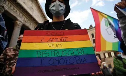  ??  ?? A protester in Rome carries an LGBT pride placard reading ‘only love can destroy homophobia’. Photograph: Riccardo Antimiani/EPA