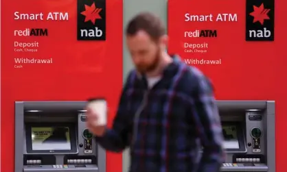  ?? Photograph: Paul Braven/EPA ?? A customer walks past National Australia Bank ATMs. The banks has apologised to customers after a gruelling week of evidence at the royal commission.