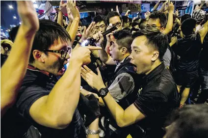  ?? XAUME OLLEROS/GETTY IMAGES ?? A protester, left, and a police officer argue in Hong Kong’s Mongkok district during clashes between rival protest groups.