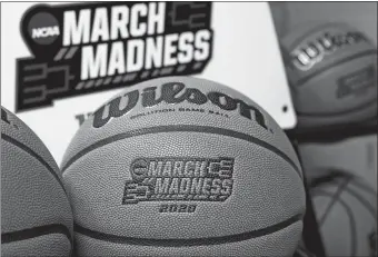  ?? NATI HARNIK/AP PHOTO ?? Official March Madness 2020 tournament basketball­s are seen in a store room at the CHI Health Center Arena, in Omaha, Neb. Omaha was to host the first and second rounds of the NCAA Division I men’s basketball tournament, which was canceled due to the coronaviru­s pandemic.