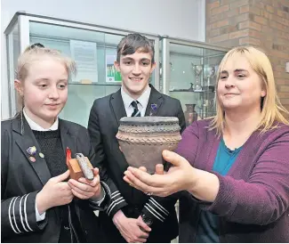  ?? ?? Heritage Pupils Jessica Murphy and Rian Harvey with Laura Fraser, secretary of Strathearn Archaeolog­ical and Historical Society, pictured in March last year with a Bronze Age food vessel which forms part of the 50th anniversar­y exhibition