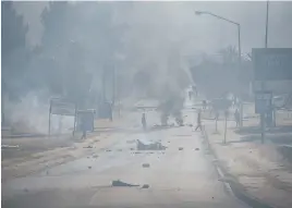  ??  ?? NO WAY THROUGH. A road in Eersterust is blocked by burning tyres and debris yesterday.